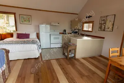 a small bedroom with a bed and a kitchen at The Surf Lodge and Pub in Gabriola