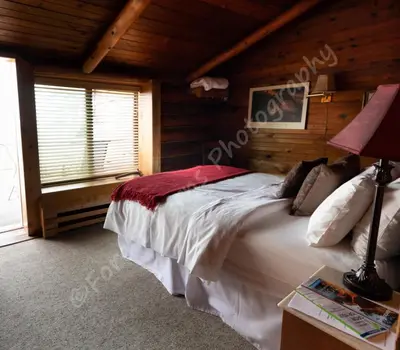 a bedroom with a large bed in a log cabin at The Surf Lodge and Pub in Gabriola