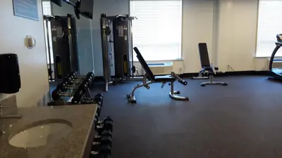 a room with a gym with a sink and chairs at Encore Suites by Service Plus Inns in Grande Prairie