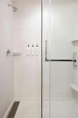 a glass shower stall with two white bottles on the wall at Fairfield Inn & Suites by Marriott West Kelowna in West Kelowna