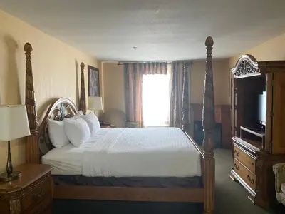 a hotel room with a bed and a television at Merit Hotel & Suites in Fort McMurray