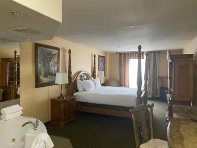 a hotel room with a bed and a bath tub at Merit Hotel & Suites in Fort McMurray