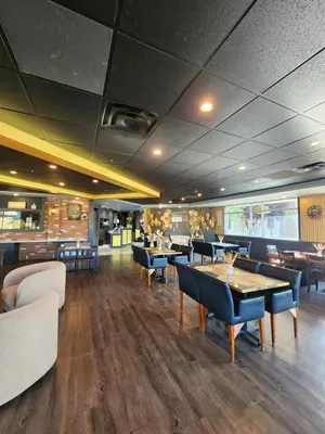 a restaurant with tables and chairs in a room at Merit Hotel & Suites in Fort McMurray