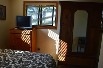 a bedroom with a bed and a television on a dresser at Estuary House Reflexology B&B in Courtenay