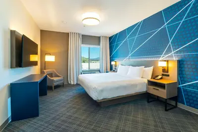 a hotel room with a bed and a desk at Comfort Suites Kelowna in Kelowna