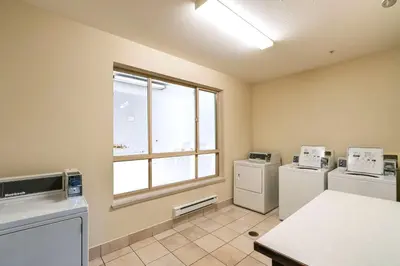 a laundry room with two appliances and a window at Comfort Inn & Suites in Surrey