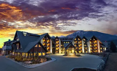 a large lodge with a mountain in the background at Grande Rockies Resort-Bellstar Hotels & Resorts in Canmore