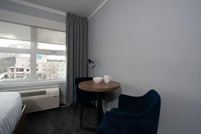 a hotel room with a table and chairs and a window at Prestige Kamloops Hotel in Kamloops
