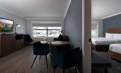 a hotel room with a bed and a table and chairs at Prestige Kamloops Hotel in Kamloops