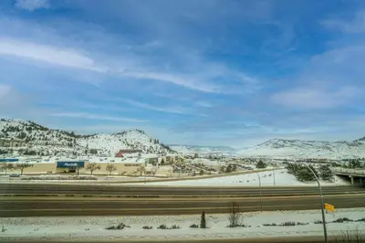 a view of a city with snow covered mountains at Prestige Kamloops Hotel in Kamloops