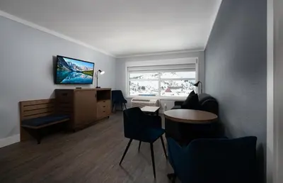 a room with a desk and chairs and a television at Prestige Kamloops Hotel in Kamloops