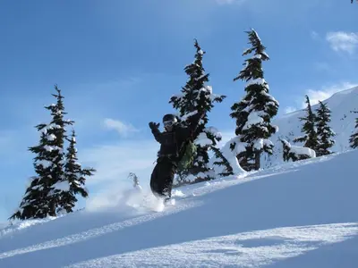 a person riding a snowboard down a snow covered slope at Guesthouse Austria in Stewart