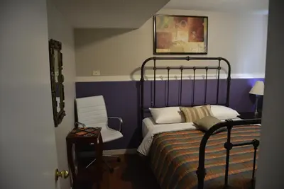 a bedroom with a bed and a chair in it at Aasra Home in Kelowna