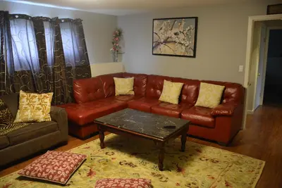 a living room with a leather couch and a coffee table at Aasra Home in Kelowna