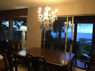 a dining room with a table and a chandelier at Garden Bridge House in Sechelt