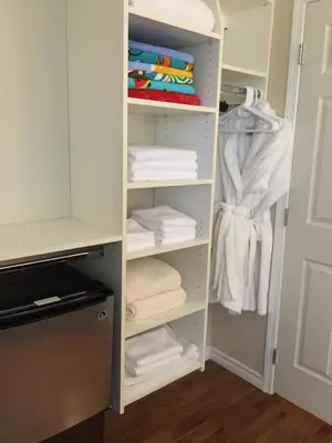 a closet with white shelves and towels at Garden Bridge House in Sechelt