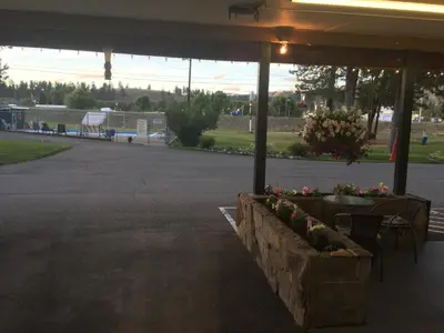 a parking lot with a table and chairs and flowers at Evergreen Motel in Princeton