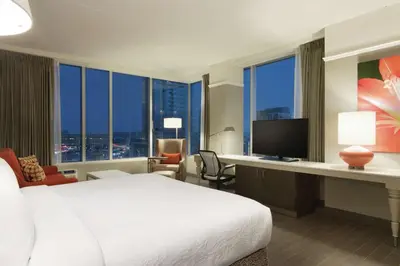 a hotel room with a bed and a desk with a television at Hilton Garden Inn Calgary Downtown in Calgary