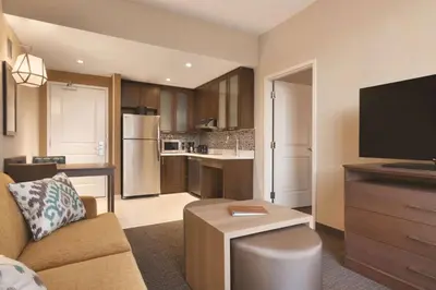 a living room with a couch and a kitchen at Homewood Suites by Hilton Calgary Downtown in Calgary