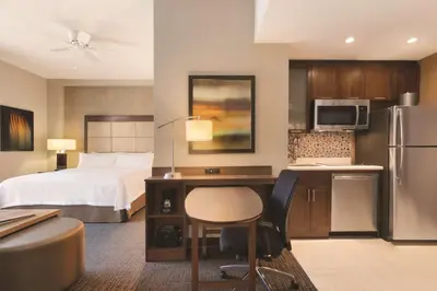 a hotel room with a bed and a desk and a kitchen at Homewood Suites by Hilton Calgary Downtown in Calgary