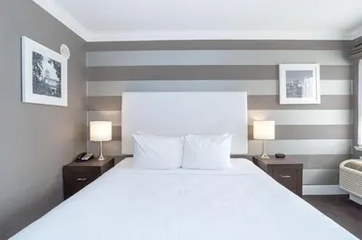 a bedroom with a large white bed with two lamps at Sandman Hotel Edmonton West in Edmonton