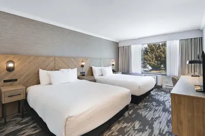 a hotel room with two beds and a window at Sandman Hotel & Suites Kelowna in Kelowna