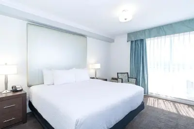 a bedroom with a large bed and a large window at Sandman Hotel & Suites Kelowna in Kelowna