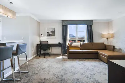 a living room with a couch and a desk at Sandman Hotel & Suites Kelowna in Kelowna