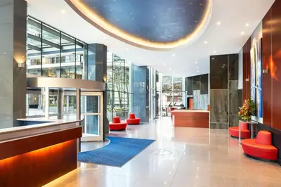 a lobby of a building with red stools at Sheraton Vancouver Wall Centre in Vancouver