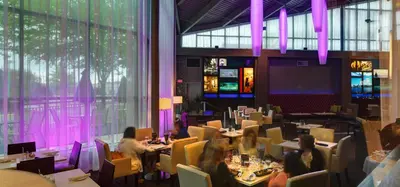 people sitting at tables in a restaurant with purple lighting at Executive Plaza Hotel & Conference Centre, Metro Vancouver in Coquitlam