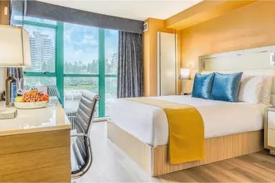 a hotel room with a bed and a desk and a window at Executive Plaza Hotel & Conference Centre, Metro Vancouver in Coquitlam