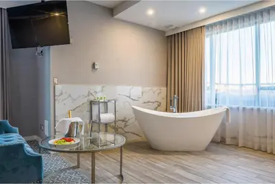a bathroom with a large tub and a table at Executive Plaza Hotel & Conference Centre, Metro Vancouver in Coquitlam