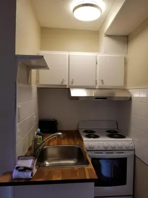 a kitchen with a sink and a stove at Sun Plaza Motel in Sundre
