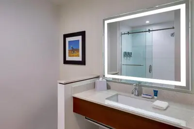 a bathroom with a sink and a large mirror at Four Points by Sheraton Sherwood Park in Sherwood Park