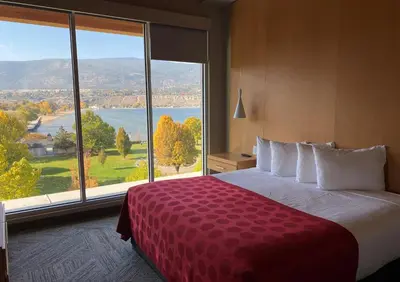 a hotel room with a large bed and a large window at Penticton Lakeside Resort in Penticton