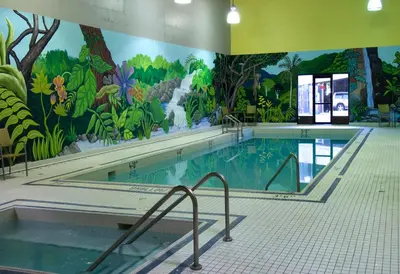 a large swimming pool with a mural on the wall at Penticton Lakeside Resort in Penticton