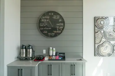 a clock on the wall above a table with a coffee maker at Prestige Vernon Lodge in Vernon