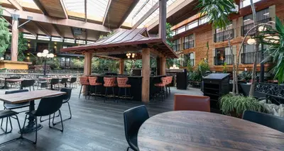 a restaurant with tables and chairs and a bar at Prestige Vernon Lodge in Vernon