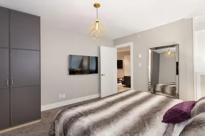 a bedroom with a large bed and a tv at Gibbons Life Accommodations in Whistler