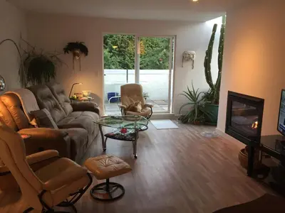 a living room with a couch and a glass table at A Room at the Camelia Bed and Breakfast in Tsawwassen