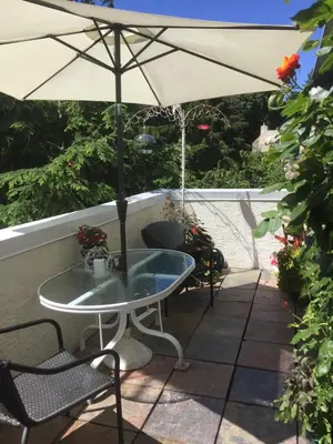 a patio with a table and an umbrella at A Room at the Camelia Bed and Breakfast in Tsawwassen