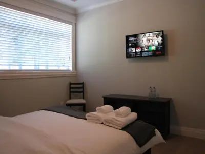 a bedroom with a bed and a tv on the wall at Riverfront Bed and Breakfast in North Vancouver