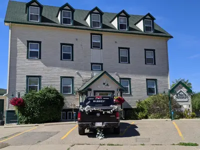 a truck parked in a parking lot in front of a building at Third Mission Heritage Suites in Peace River