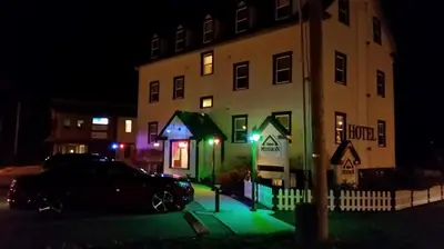 a car parked in front of a building at night at Third Mission Heritage Suites in Peace River