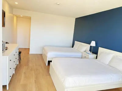 a bedroom with two beds and a blue wall at Riverside Inn in Wabasca
