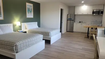 a hotel room with two beds and a kitchen at Riverside Inn in Wabasca