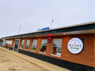 a building with a sign on the side of it at Riverside Inn in Wabasca