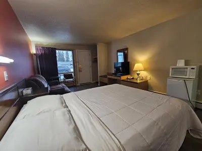a hotel room with a bed and a microwave at Howard Johnson by Wyndham Edson in Edson