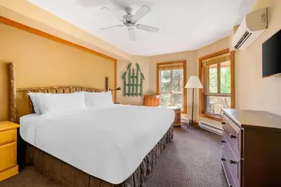 a bedroom with a large white bed and windows at Hilton Grand Vacations Club Whistler in Whistler