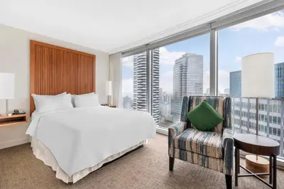a bedroom with a large bed and a large window at Embarc Vancouver in Vancouver